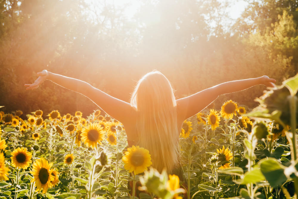Woman spenind time under the sun in sunflower field